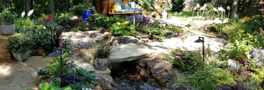 backyard full of plants and stone bridge