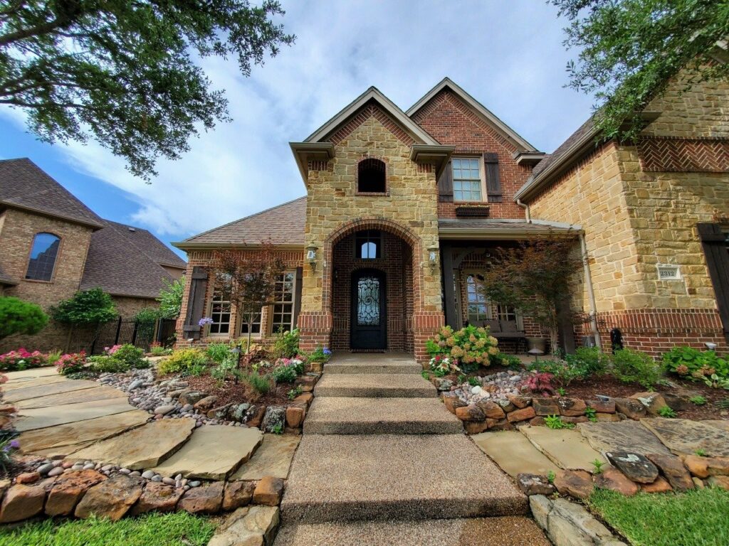 front view of a home with flower beds and stone pathways